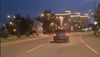 В Тынде молодой человек едет на автомобиле, стоя на его крыше.
